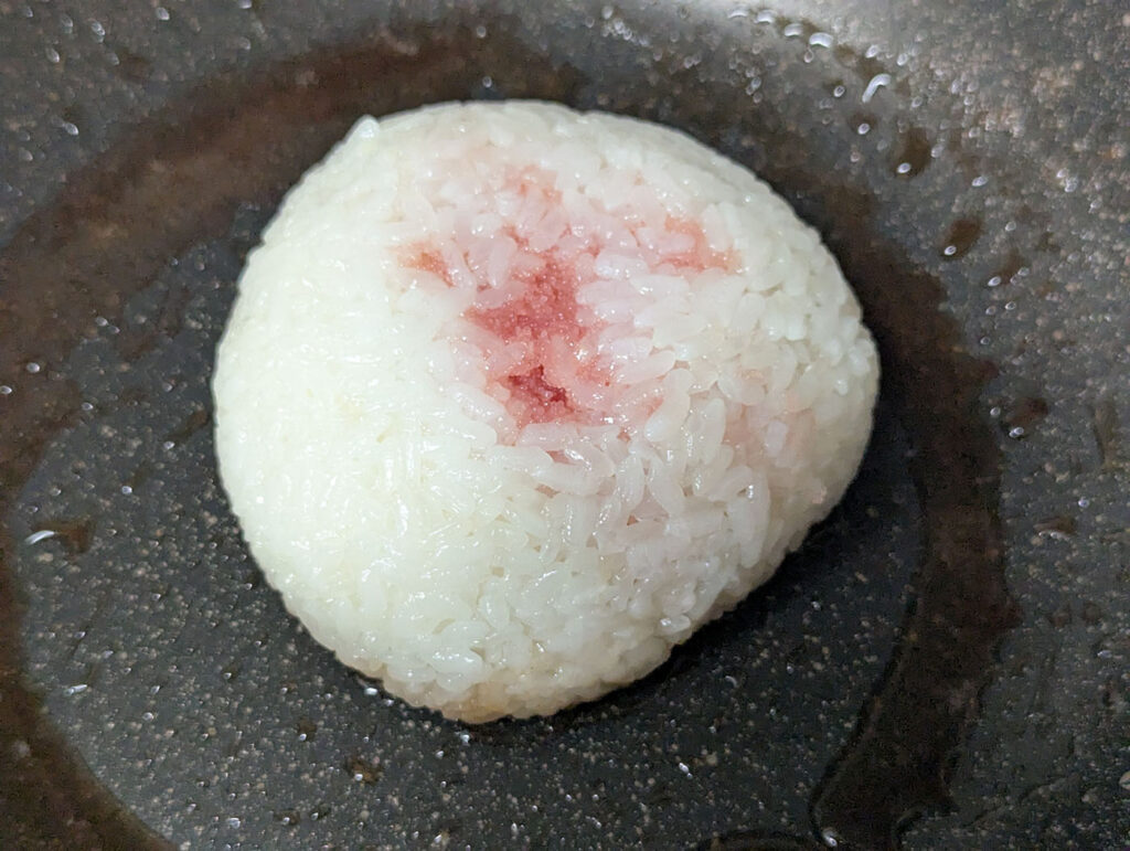 タラバガニとたらこのモチコメ焼きおにぎりをバターたっぷりのフライパンで焼く